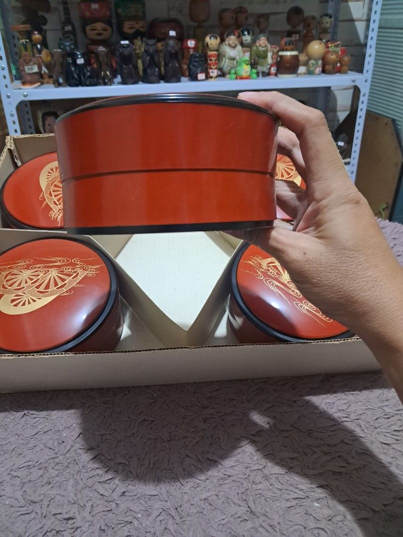 Set (Category: Dinnerware & Cutlery) located in Cavite. Submitted by secretjapansurplus (Listing ID 1469902212, Image 3). Description: This is a vintage 5-piece set of Japanese lidded lacquerware (shikki) bowls, likely from the Showa era. The vibrant vermilion red lids are decorated with an elegant "波車" (namiguruma) wave-and-cart-wheel motif, crafted using traditional gold Maki-e (蒔絵) powder techniques. The bowls feature contrasting glossy black 