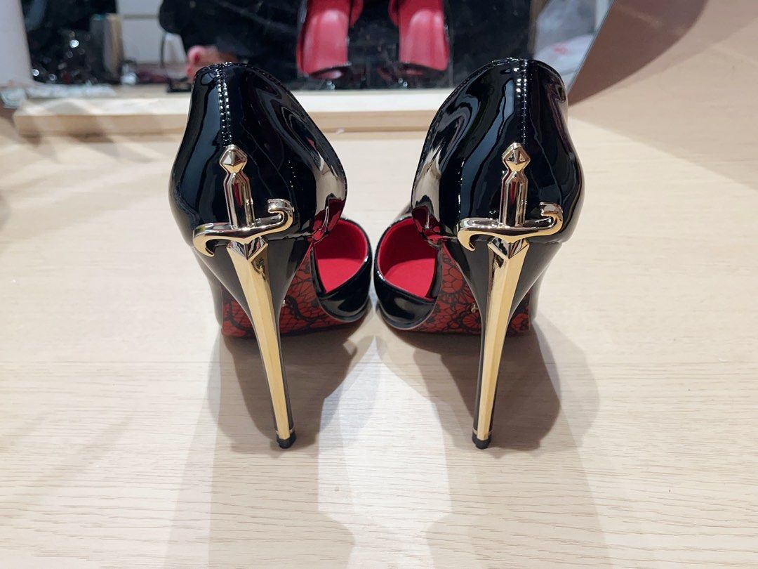 Shein Dagger/Sword stiletto heels cesare paccioti style (Category: Heels) located in Makati City. Submitted by maxgomez (Listing ID 1469787262, Image 3). Description: - Glossy black patent finish with a sleek pointed-toe design - Eye-catching gold dagger-shaped stiletto heel on the back - Signature red sole featuring a chic black lace print and tiny dagger emblem - Convenient slip-on style for easy wear - Perfect statement shoes for parties, even