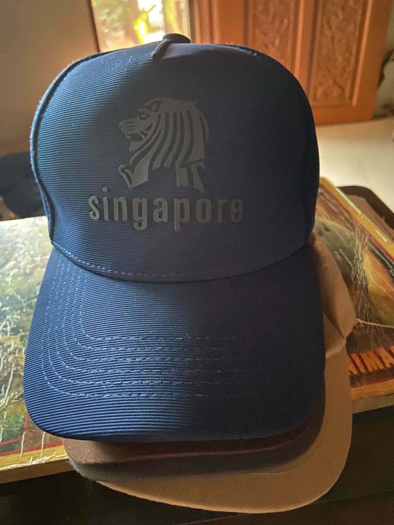 Singapore Lion Head Blue Baseball Cap (Category: Caps & Hats) located in Zaragoza. Submitted by sherree1281 (Listing ID 1469895066, Image 1). Description: - Color: Blue - Design: Iconic Singapore lion head logo on the front - Fit: Structured front panel with a classic curved brim - Closure: Adjustable strap at the back for a customized fit - Condition: Clean fabric with solid, durable stitching.