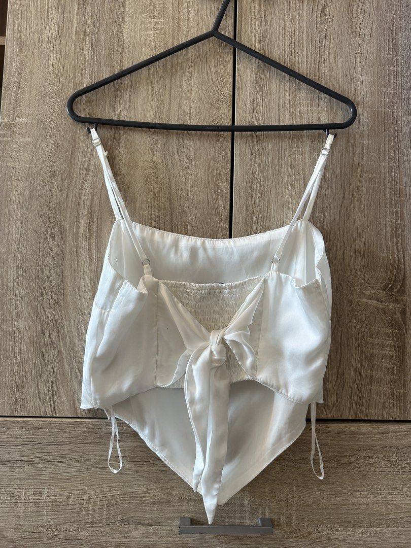 Stradivarius White Satin Tie Back Crop Top Size M (Category: Sleeveless) located in Pateros City. Submitted by overandout. (Listing ID 1469841910, Image 2). Description: - Brand: Stradivarius - Color: White - Size: Medium - Material: Smooth satin fabric - Design: Tie-back closure with smocked back panel, adjustable spaghetti straps, and chic pointed hem - Condition: Excellent pre-loved condition.