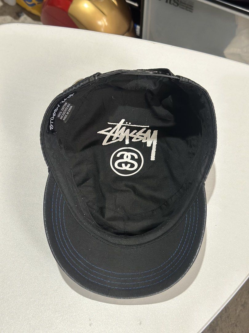 Stüssy Increasing the Peace Black Cadet Hat (Category: Caps & Hats) located in Daet. Submitted by thrifthings2018 (Listing ID 1469847808, Image 2). Description: - Brand: Stüssy - Style: Cadet hat / Military cap - Material: 100% cotton with inner logo lining - Color: Black with blue contrast stitching along the brim - Details: White side embroidery ('Increasing the Peace Since 1980') and 30th anniversary back graphic - Fit: Adjustable strap closur