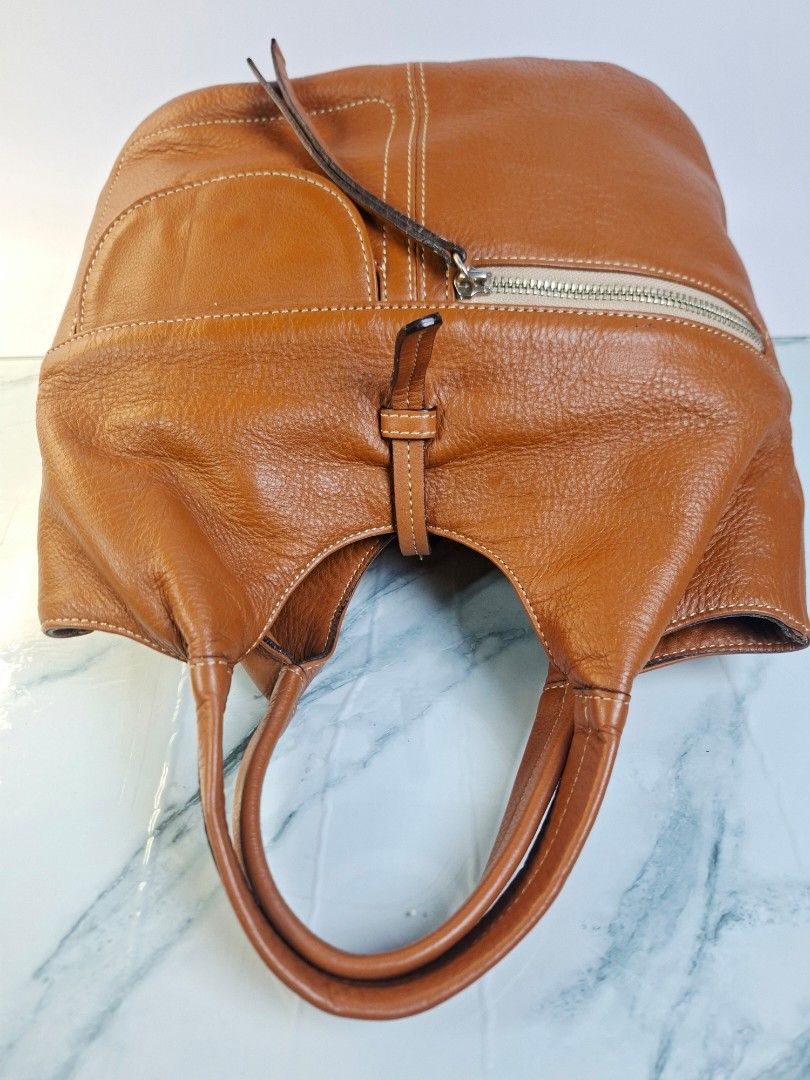 Tan Brown Leather Bag with Front Pocket and Zips (Category: Shoulder Bags) located in Pasay City. Submitted by onick_79 (Listing ID 1469926989, Image 3). Description: -Dimensions: L 28 x H 25 x W 18cm - Material: Tan pebbled leather with contrasting white topstitching - Handles: Structured dual top handles for easy carrying - Pockets: Front flap pocket with magnetic snap closure - Accents: Stylish vertical zipper details on the front and back ext
