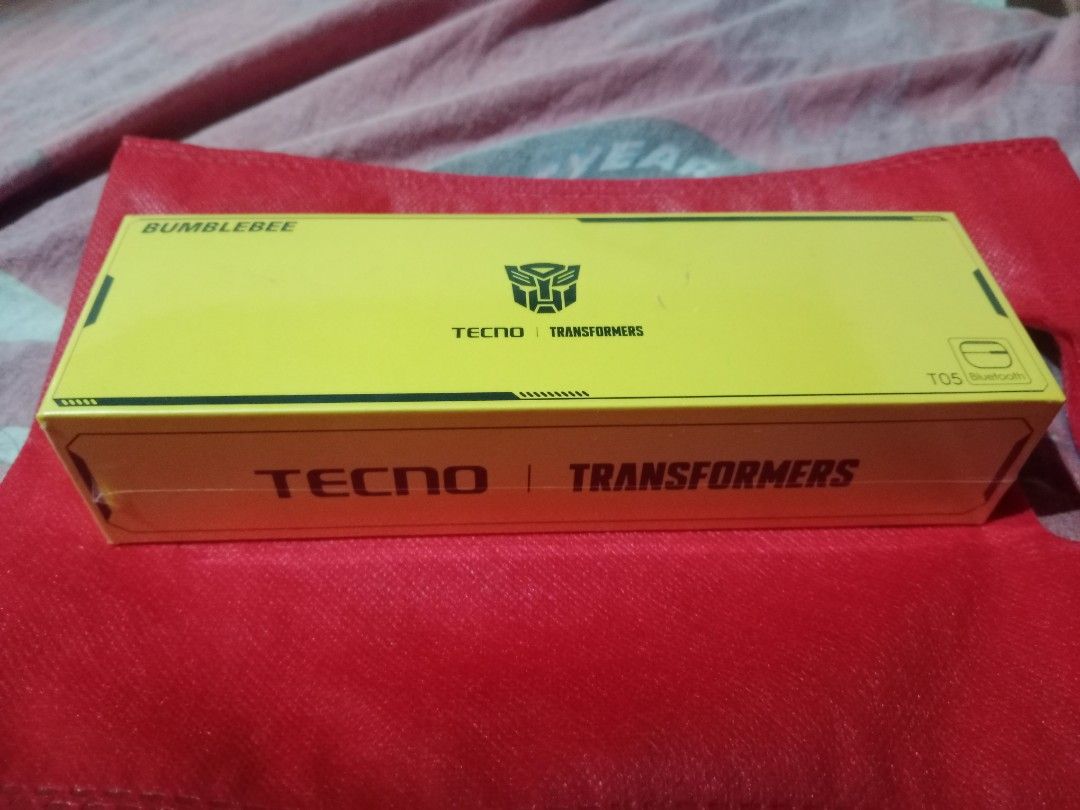 Tecno Transformers Bumblebee T05 Bluetooth Earbuds (Category: Earphones) located in Manila. Submitted by hapondevera_41 (Listing ID 1469898695, Image 1). Description: Official Tecno and Transformers collaboration wireless earbuds. Bumblebee yellow themed packaging featuring the Autobot logo. Model T05 Bluetooth earphones inside. Licensed by Hasbro and Paramount Pictures. Rare collectible audio gear for fans. Unused item in original sealed box..