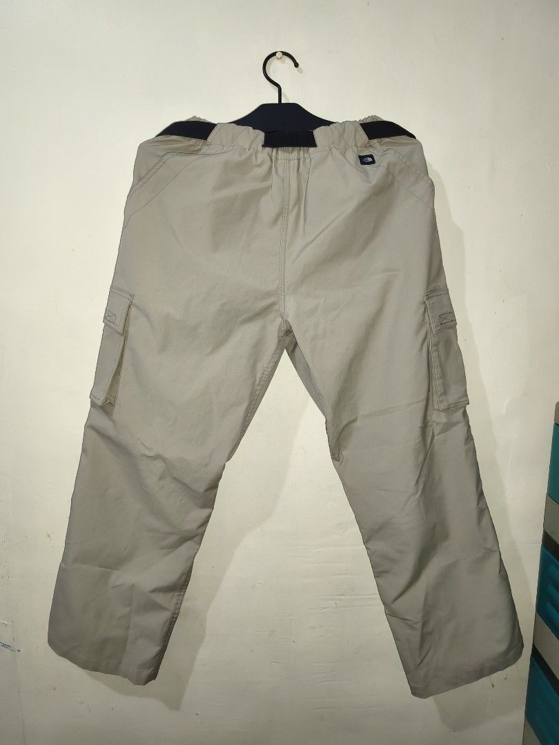 The North Face Beige Cargo Pants Size M (Category: Trousers) located in Bulacan. Submitted by THA_D_THRIFT (Listing ID 1469856469, Image 2). Description: North Face cargo pants in beige, size medium. Built with an integrated black web belt and quick-release plastic buckle. Multiple utility pockets on both legs. Elastic waistband with snap button closure. Embroidered brand logo patches on the back and thigh. GOOD AS NEW W 28-36 L 36.5 H 9 1700 + S