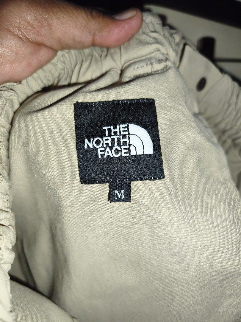 The North Face Beige Cargo Pants Size M (Category: Trousers) located in Bulacan. Submitted by THA_D_THRIFT (Listing ID 1469856469, Image 3). Description: North Face cargo pants in beige, size medium. Built with an integrated black web belt and quick-release plastic buckle. Multiple utility pockets on both legs. Elastic waistband with snap button closure. Embroidered brand logo patches on the back and thigh. GOOD AS NEW W 28-36 L 36.5 H 9 1700 + S