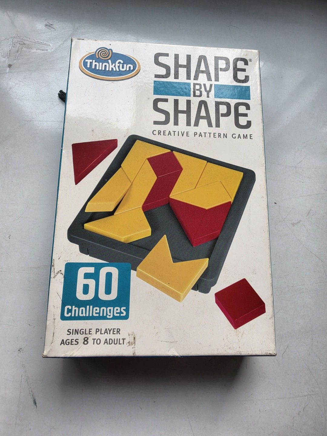 ThinkFun Shape by Shape Creative Pattern Game (Category: Board Games & Puzzles) located in Singapore. Submitted by nicijunior (Listing ID 1469760735, Image 4). Description: - Game: ThinkFun Shape by Shape Creative Pattern Game - For ages 8 to adult (Single player) - Includes 60 challenging puzzles, game tray, and 14 shape pieces - Convenient slide-out card storage and bonus game-go bag - Great brain teaser and educational gift idea - Condition: c