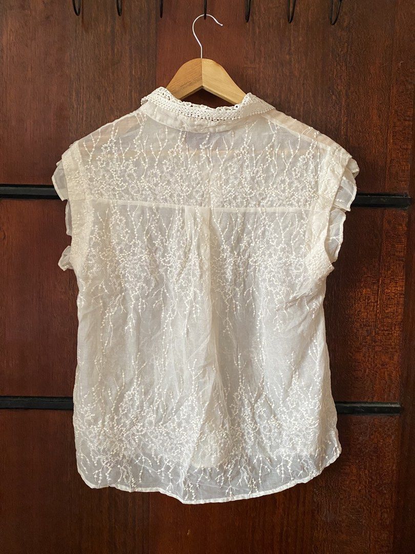 [THRIFTED & AVAILABLE] Lace Collar Button-Up Blouse White (Category: Blouses) located in Quezon City. Submitted by yaku1t (Listing ID 1469761825, Image 3). Description: - Free Size (best fits XS-Semi M) - Material: Lightweight and airy fabric (slightly see through) - Design: All-over intricate lace embroidery with front button closure - Details: Cute ruffles on sleeves and a standout cutout lace collar - Styling: Perfect for layering or wearing s
