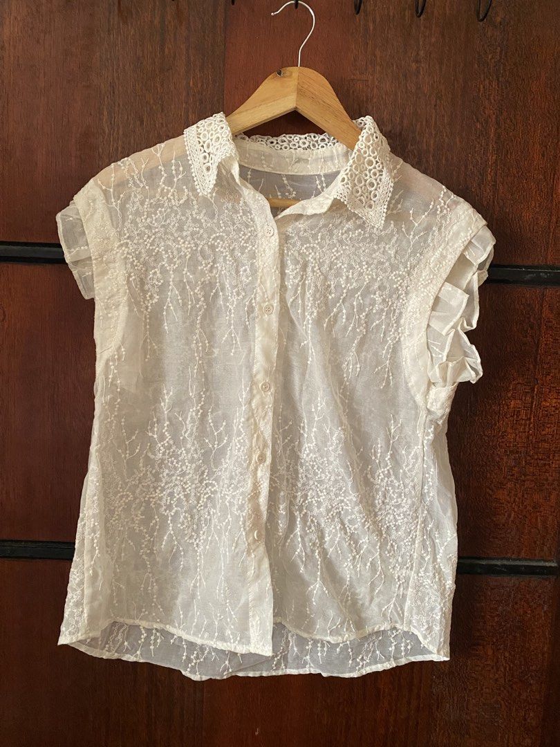 [THRIFTED & AVAILABLE] Lace Collar Button-Up Blouse White (Category: Blouses) located in Quezon City. Submitted by yaku1t (Listing ID 1469761825, Image 2). Description: - Free Size (best fits XS-Semi M) - Material: Lightweight and airy fabric (slightly see through) - Design: All-over intricate lace embroidery with front button closure - Details: Cute ruffles on sleeves and a standout cutout lace collar - Styling: Perfect for layering or wearing s
