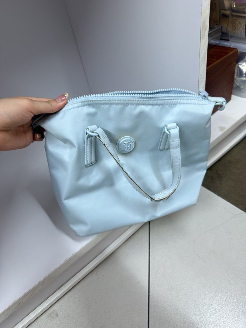Tommy Hilfiger Light Blue Handbag (Category: Shoulder Bags) located in Manila. Submitted by btsalbumssssss (Listing ID 1469840118, Image 1). Description: - Brand: Tommy Hilfiger - Color: Light Blue - Material: Durable and lightweight nylon - Handles: Double top handles for easy carrying - Exterior: Chic circular logo badge centered on the front - Closure: Secure main compartment with zip closure - Interior Organization: Includes built-in slip poc