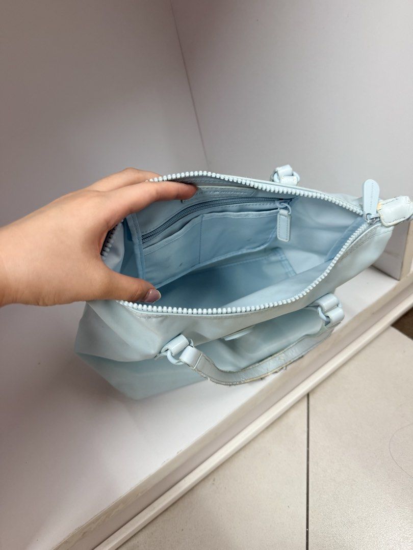 Tommy Hilfiger Light Blue Handbag (Category: Shoulder Bags) located in Manila. Submitted by btsalbumssssss (Listing ID 1469840118, Image 2). Description: - Brand: Tommy Hilfiger - Color: Light Blue - Material: Durable and lightweight nylon - Handles: Double top handles for easy carrying - Exterior: Chic circular logo badge centered on the front - Closure: Secure main compartment with zip closure - Interior Organization: Includes built-in slip poc