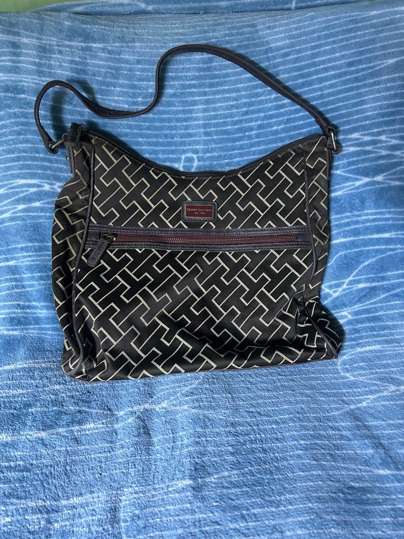Tommy Hilfiger Monogram Shoulder Bag Dark Brown (Category: Shoulder Bags) located in Quezon City. Submitted by thriftxgoods (Listing ID 1469897100, Image 1). Description: - Brand: Tommy Hilfiger - Color/Pattern: Dark brown with iconic monogram print and dark leather trim - Storage: Main compartment with top zipper closure, inner lined pocket with brand tag, and a convenient front zippered pocket - Strap: Adjustable shoulder strap secured with dur