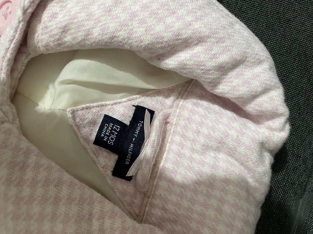 Tommy Hilfiger Pink Houndstooth Coat 12 Months (Category: Babies & Kids Fashion) located in San Fernando. Submitted by agustinjonna (Listing ID 1469879130, Image 2). Description: - Brand: Tommy Hilfiger - Item: Baby girls houndstooth coat - Color: Pink and white - Size: 12 months - Design: Double-breasted front with branded pink buttons and small embroidered logo near the pocket - Interior: Fully lined in smooth white satin - Condition: Excellent