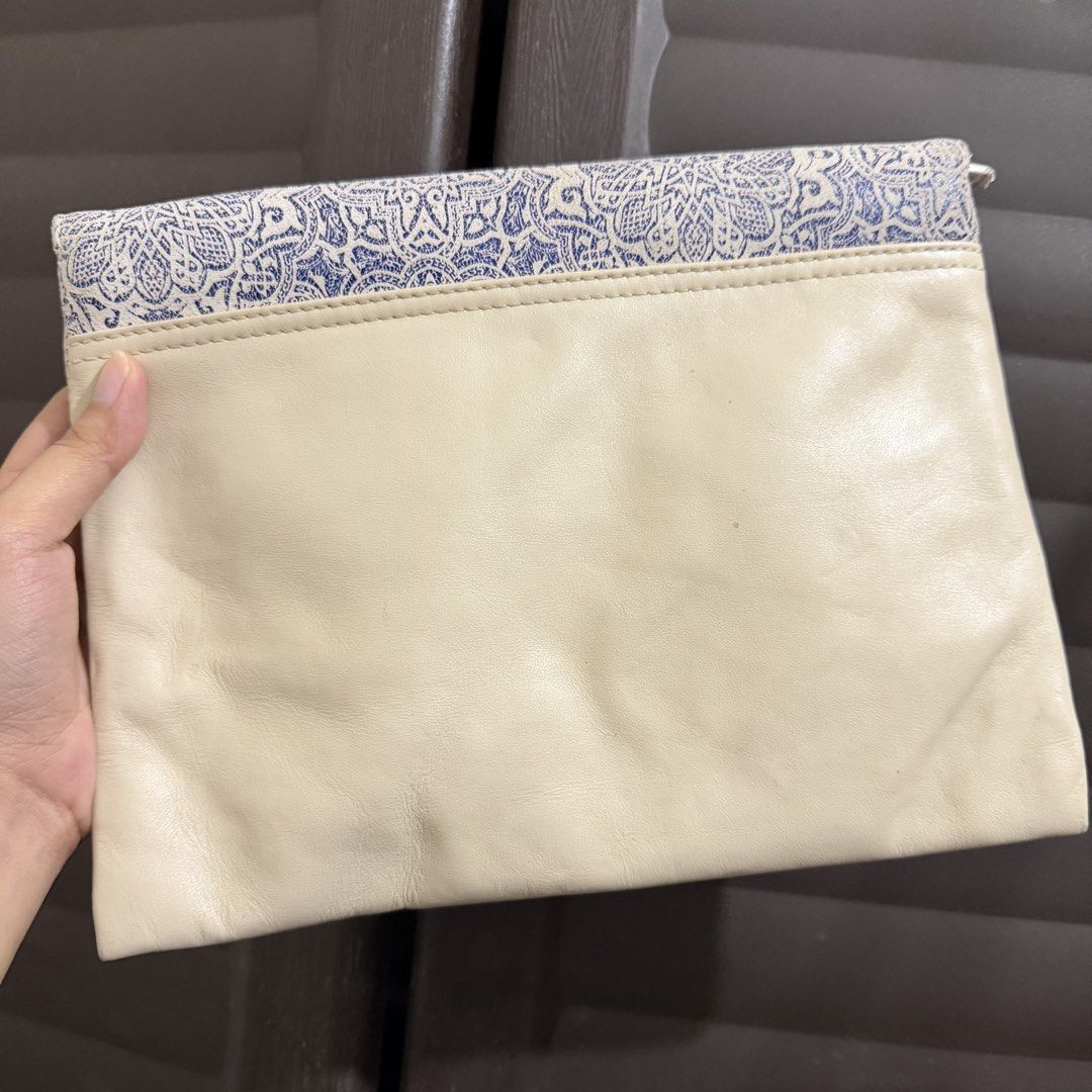 TOMS Blue Tile Printed Clutch Cream (Category: Clutches) located in Rizal. Submitted by lovegclothingph (Listing ID 1469886444, Image 2). Description: - Brand: TOMS - Condition: Brand new with tags attached - Design: Blue and white tile-printed linen flap with a cream-colored leather body - Closure: Envelope-style fold-over flap with magnetic snap and zippered main compartment - Interior: Fabric-lined with an extra zippered pocket for organizatio