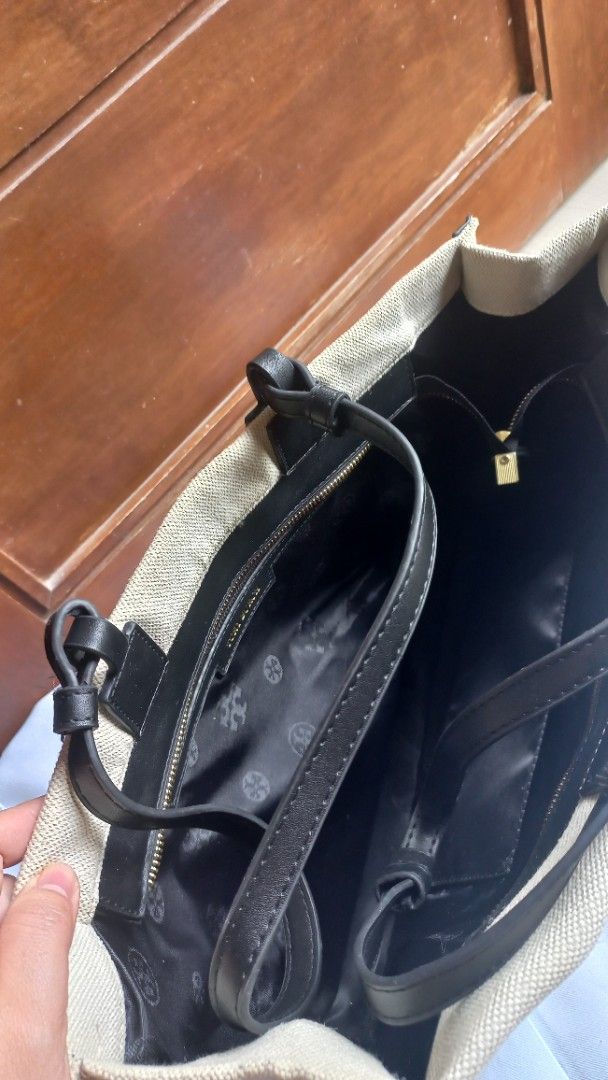 Tory Burch Canvas Tote Bag Black Beige (Category: Tote Bags) located in Rizal. Submitted by mayra74 (Listing ID 1469945064, Image 2). Description: - Brand: Tory Burch - Color: Beige and black with black leather trim - Design: Large cut-out logo on the front - Interior: Monogram fabric lining with a zip pocket and inner compartments - Straps: Double shoulder straps - Use: Spacious and versatile daily carrier for work, campus, or errands.