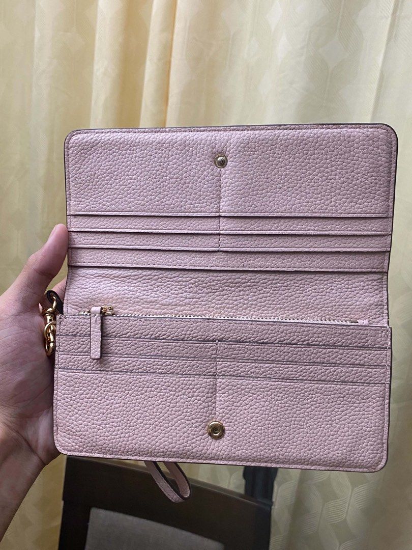 Tory Burch Pink Leather Wristlet Wallet (Category: Luxury Bags & Wallets) located in Cagayan de Oro. Submitted by caga67813 (Listing ID 1469914607, Image 2). Description: - Brand: Tory Burch - Material: Pale pink pebble leather - Hardware: Gold-tone with classic front logo stamp - Closure: Snap button - Interior: Multiple card slots and a secure zippered compartment - Extras: Attached side wrist strap - Condition: Clean inside and out, perfect fo