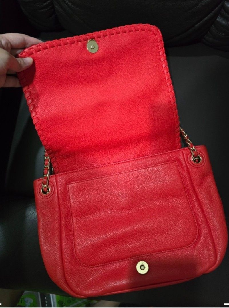 Tory Burch Red Leather Shoulder Bag (Category: Luxury Bags & Wallets) located in Quezon City. Submitted by jazz1718 (Listing ID 1469920493, Image 2). Description: - Red crossbody bag - Chain strap with leather accents - Flap closure with gold-tone button - Interior zippered pocket - Includes dust bag - Tory Burch logo on front - Unique stitching detail.