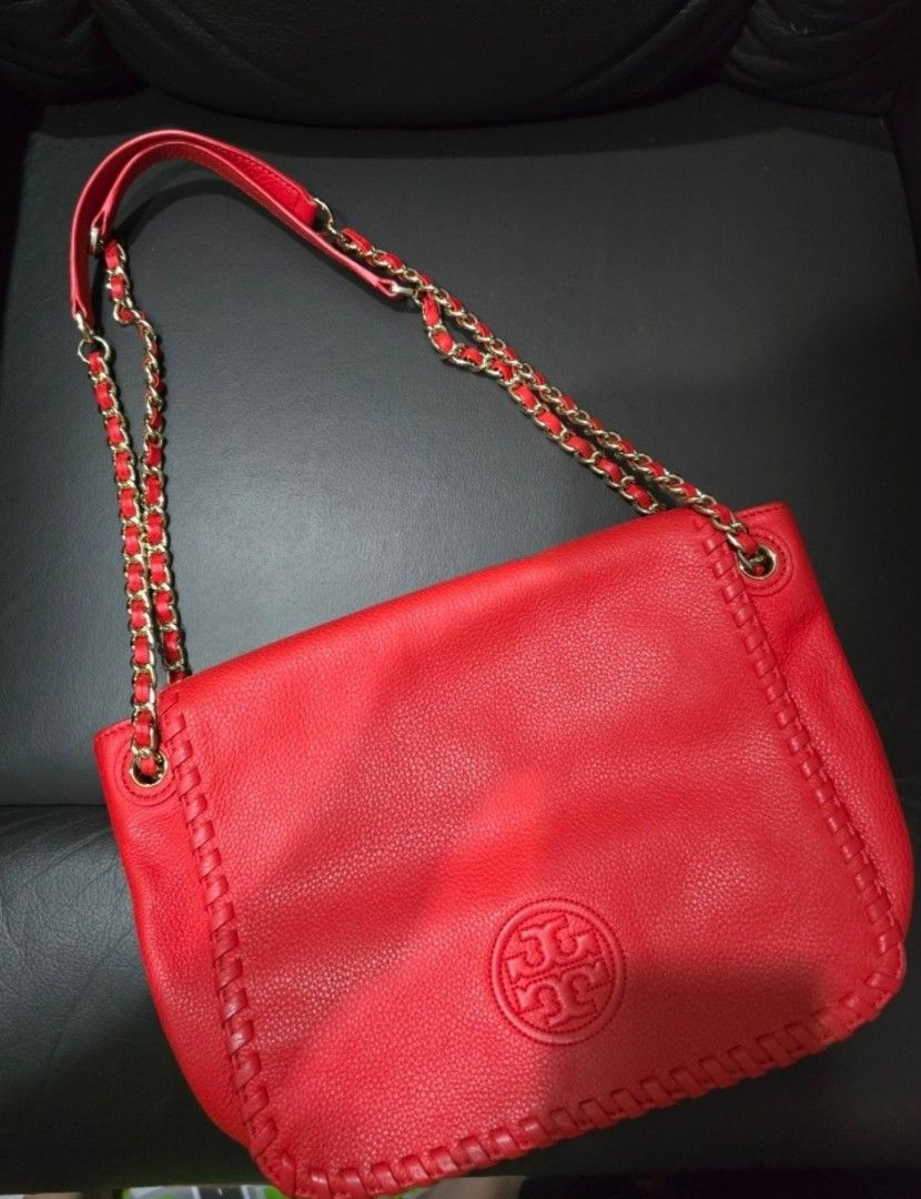 Tory Burch Red Leather Shoulder Bag (Category: Luxury Bags & Wallets) located in Quezon City. Submitted by jazz1718 (Listing ID 1469920493, Image 1). Description: - Red crossbody bag - Chain strap with leather accents - Flap closure with gold-tone button - Interior zippered pocket - Includes dust bag - Tory Burch logo on front - Unique stitching detail.