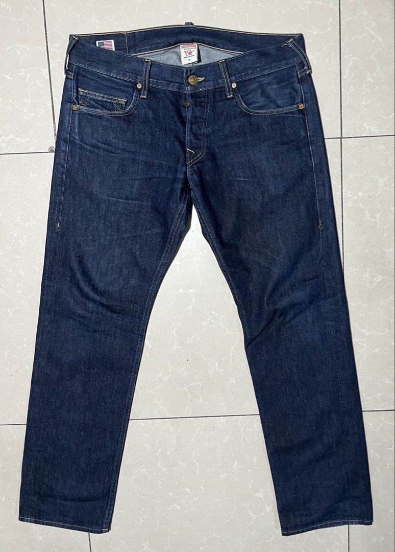 True Religion Geno (Category: Jeans) located in Cebu City. Submitted by rockall24455 (Listing ID 1469909421, Image 2). Description: - Brand: True Religion - Style: Dark wash denim jeans with standard straight leg fit - Origin: Made in USA - Size: Tagged Size 36 on interior label - Closure: Button fly - Details: Classic horseshoe back pocket stitching and leather back patch - Condition: Clean denim fabric, ready to wear.