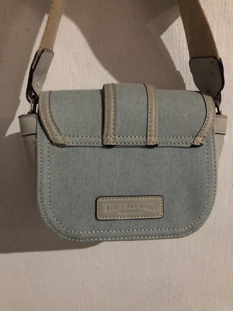 True Religion Sling Bag (Category: Cross-body Bags) located in Vigan. Submitted by chiyannav (Listing ID 1469869152, Image 3). Description: from US True Religion Mini Horseshoe Bag in a blue and grey/beige colorway. • Brand: True Religion • Style: Mini flap crossbody / shoulder bag with a prominent metallic horseshoe logo on the front flap • Material: Faux leather trim with denim/fabric body and an adjustable grosgrain strap.