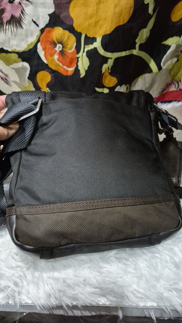 TUMI Black and Brown Crossbody Bag (Category: Cross-body Bags) located in Baguio. Submitted by jhaz_bags (Listing ID 1469900768, Image 3). Description: - Brand: TUMI - Color: Black and brown - Material: Durable ballistic nylon with leather trim - Compartments: Multiple zippered compartments for easy organization - Strap: Adjustable black shoulder strap included - Condition: Clean interior and exterior, ready to use - Best for: Daily commute, trav