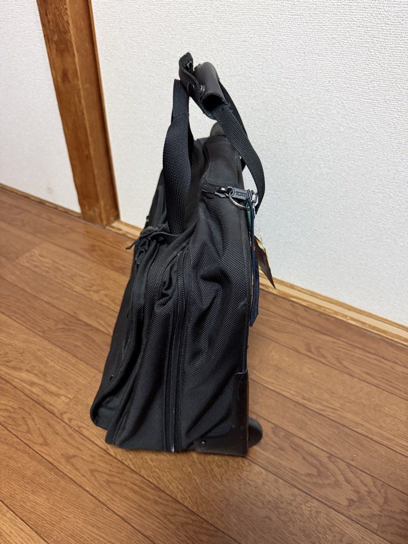 TUMI Rolling Briefcase Business Travel Bag (Category: Briefcases) located in Pasay City. Submitted by closetbykim (Listing ID 1469946220, Image 2). Description: - Brand: TUMI - Color: Classic Black - Type: Rolling business case / pilot bag - Features: Smooth-rolling wheels, working telescoping handle, leather-wrapped top carry handles, and original luggage tag - Storage: Multiple zippered compartments on the front and back for optimal organizatio