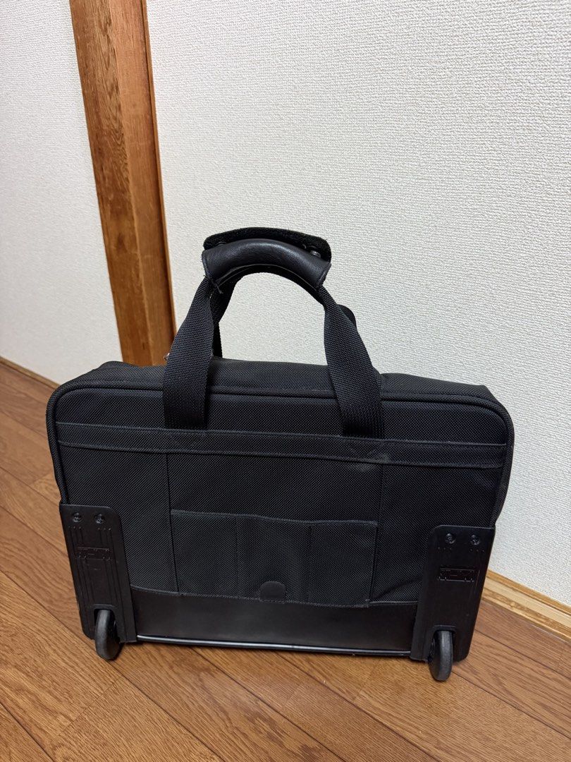TUMI Rolling Briefcase Business Travel Bag (Category: Briefcases) located in Pasay City. Submitted by closetbykim (Listing ID 1469946220, Image 3). Description: - Brand: TUMI - Color: Classic Black - Type: Rolling business case / pilot bag - Features: Smooth-rolling wheels, working telescoping handle, leather-wrapped top carry handles, and original luggage tag - Storage: Multiple zippered compartments on the front and back for optimal organizatio