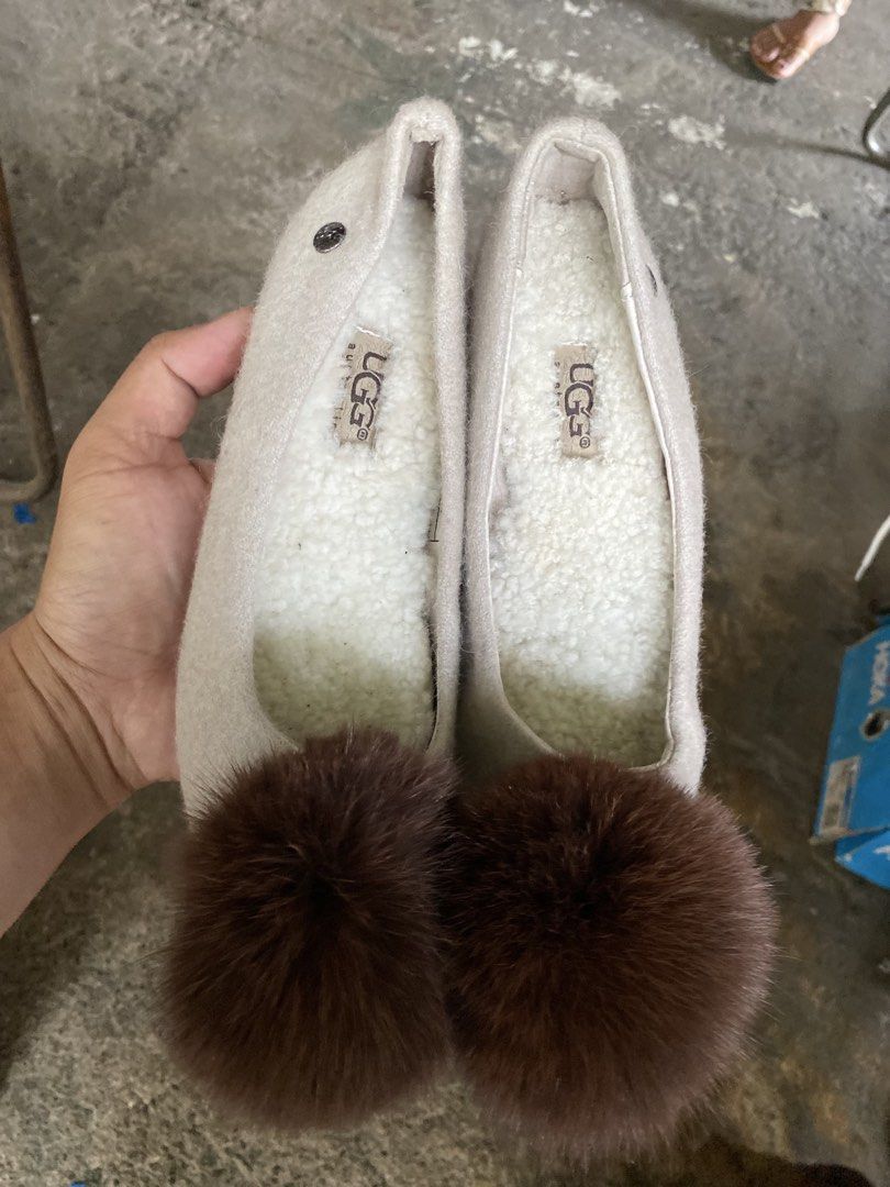 UGG Slippers with Pom Pom Cream Color (Category: Slippers and slides) located in Alburquerque. Submitted by zanegavynn43872 (Listing ID 1469944505, Image 1). Description: - Brand: UGG - Color: Cream with white fleece lining - Feature: Large brown fur pom pom on the front toe - Material: Soft felt upper - Sole: Flat with all-over UGG logo pattern, minimal wear - Style: Easy slip-on for casual indoor/outdoor use.