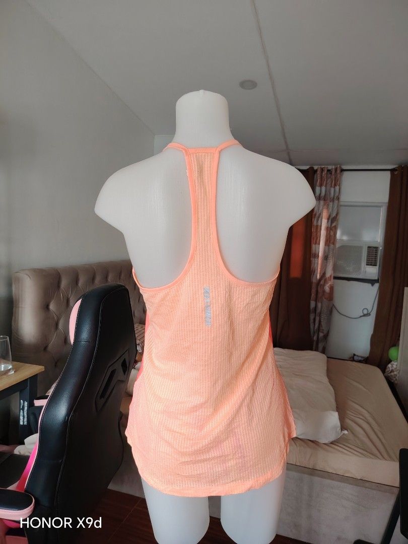 Under Armour HeatGear Workout Tank Top (Category: Sleeveless) located in Mabalacat. Submitted by Jackikay.PreLoved (Listing ID 1469848558, Image 2). Description: Bright peach Under Armour athletic tank top. HeatGear mesh fabric keeps you cool during workouts. Racerback design with vertical Under Armour text on the back spine. Small UA logo on the lower hem. Size LG on the inner tag. Made in the Philippines..