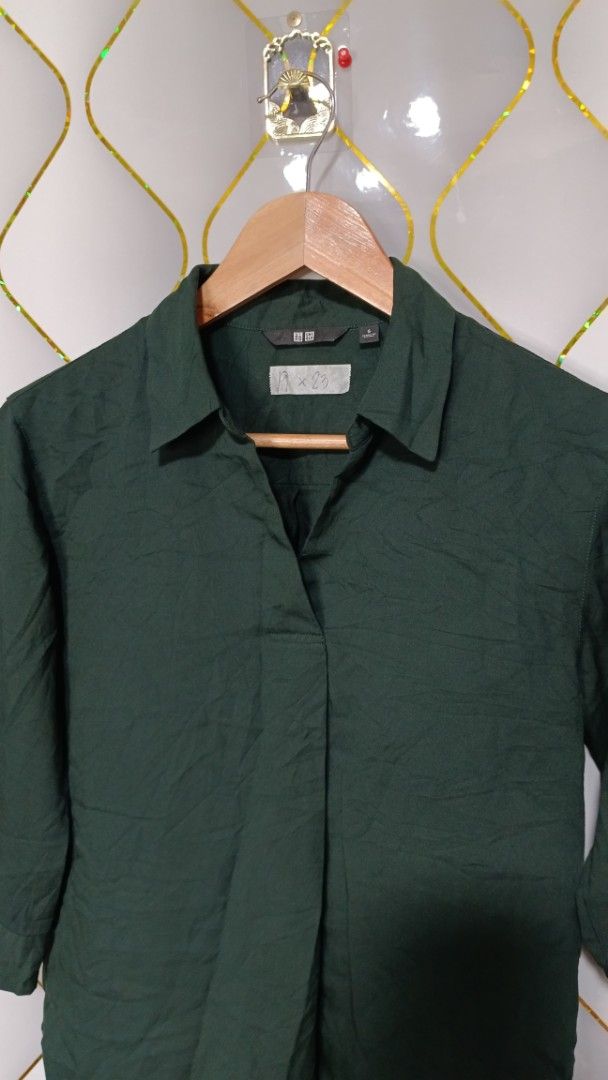 Uniqlo Dark Green Blouse (Category: Shirts) located in Manila. Submitted by zariyah.1986 (Listing ID 1469857333, Image 2). Description: - Brand: Uniqlo - Color: Dark Green - Size: Small (S) - Design: Collar neck with 3/4 sleeves - Material: Lightweight and smooth fabric - Measurements: Pit to pit ~19", Length ~23" - Condition: Clean and ready to wear - Versatile: Great for casual work days or weekend outings.