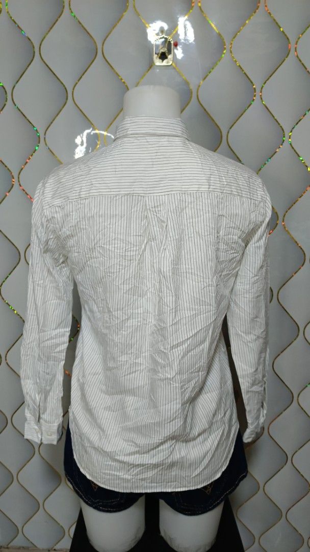 Uniqlo Striped Long Sleeve Button-Down Blouse (Category: Longsleeves) located in Manila. Submitted by zariyah.1986 (Listing ID 1469810749, Image 3). Description: - Brand: Uniqlo - Style: Long sleeve button-down blouse - Color/Pattern: White with thin vertical stripes - Size: S - Material: 76% rayon, 24% polyester - Details: Collared neckline, front button closure, standard button cuffs - Origin: Made in China.