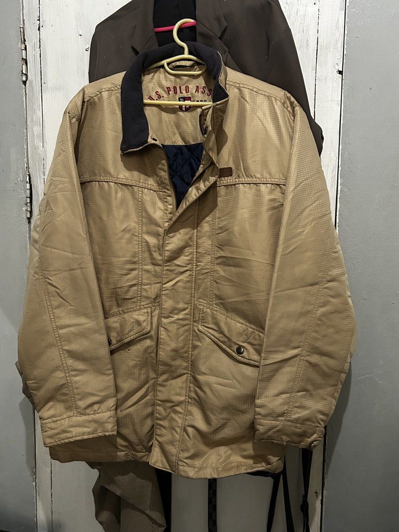 U.S. Polo Assn. Khaki Winter Jacket (Category: Coats, Jackets and Outerwear) located in Ozamiz City. Submitted by kkaier7777 (Listing ID 1469776294, Image 3). Description: - Brand: U.S. Polo Assn. - Color: Khaki exterior with quilted navy blue inner lining - Collar: Dark fleece collar with embroidered logo lettering inside - Closure: Full zip front with button-flap - Features: Practical front pockets - Condition/Material: Thick, heavy-duty outerw