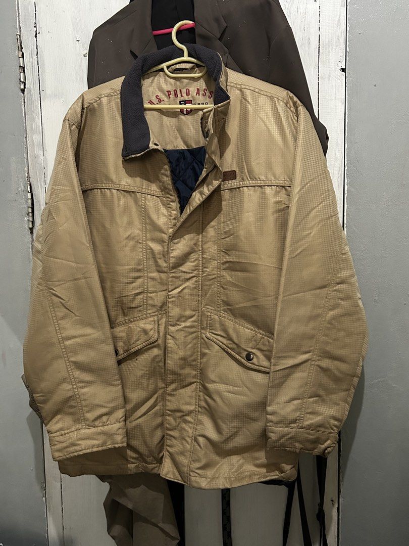 U.S. Polo Assn. Khaki Winter Jacket (Category: Coats, Jackets and Outerwear) located in Ozamiz City. Submitted by kkaier7777 (Listing ID 1469776294, Image 1). Description: - Brand: U.S. Polo Assn. - Color: Khaki exterior with quilted navy blue inner lining - Collar: Dark fleece collar with embroidered logo lettering inside - Closure: Full zip front with button-flap - Features: Practical front pockets - Condition/Material: Thick, heavy-duty outerw