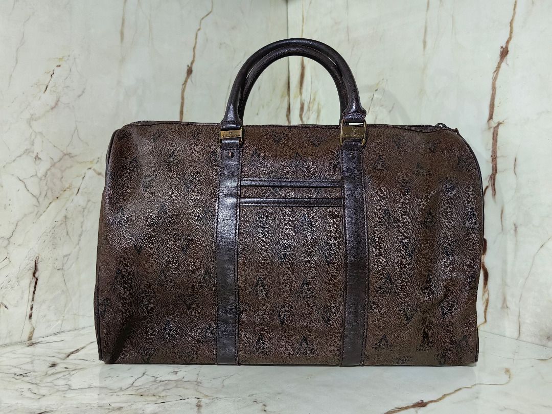 Valentino Brown Monogram Travel Duffel Bag (Category: Luxury Bags & Wallets) located in Tarlac. Submitted by jeremiah.curator.2026 (Listing ID 1469768730, Image 3). Description: - Brand: Valentino - Color/Design: Dark brown with all-over monogram print and leather-look trim - Hardware: Gold-tone accents on handle connector rings - Closure: Secure top zip - Features: Side rings for optional shoulder strap attachment - Capacity: Generous size, idea