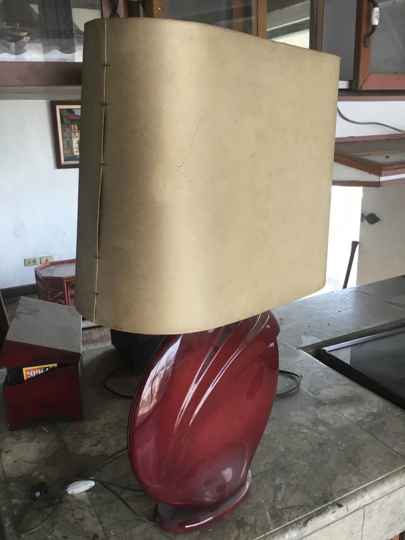 Vintage Ceramic Table Lamp with Beige Shade (Category: Lighting) located in Manila. Submitted by roberto.enriquez (Listing ID 1469816907, Image 2). Description: - Unique deep red ceramic base with flowing carved details - Large rectangular beige lampshade featuring visible side stitching - Heavy statement piece ideal for bedside tables or living room sideboards - Fully working electrical cord with standard plug attached Height 30 inches .