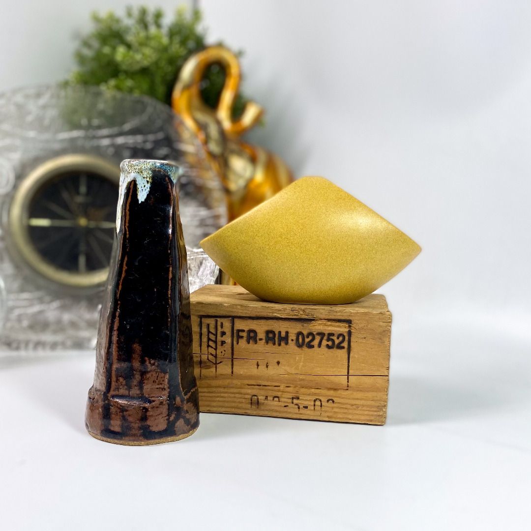 Vintage Ceramic Vases 101426-067 (Category: Vases & Decorative Bowls) located in Quezon City. Submitted by madiscollectibles (Listing ID 1469796099, Image 2). Description: - Vase 1: Tall dark brown piece featuring a striking white drip glaze at the top Left Ikebana Glazed Stoneware Vase Signed at the bottom Height:18 cm Price:425.00 - Vase 2: Mustard yellow diamond-shaped vase with dual openings and Japanese-style painted artwork and calligraphy 