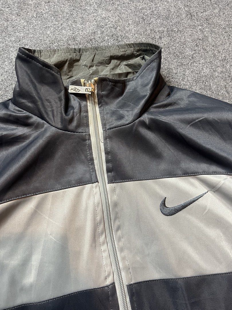 Vintage Nike Track Jacket Grey Black Size M (Category: Coats, Jackets and Outerwear) located in Lapu Lapu. Submitted by softfind (Listing ID 1469823405, Image 2). Description: - Authentic vintage Nike track jacket in a stylish grey and black colorway - Made in Italy with premium quality - Features a full zip closure, stand-up collar with a packable hood, and practical side pockets - Detailed with a large embroidered Nike swoosh on the chest and m