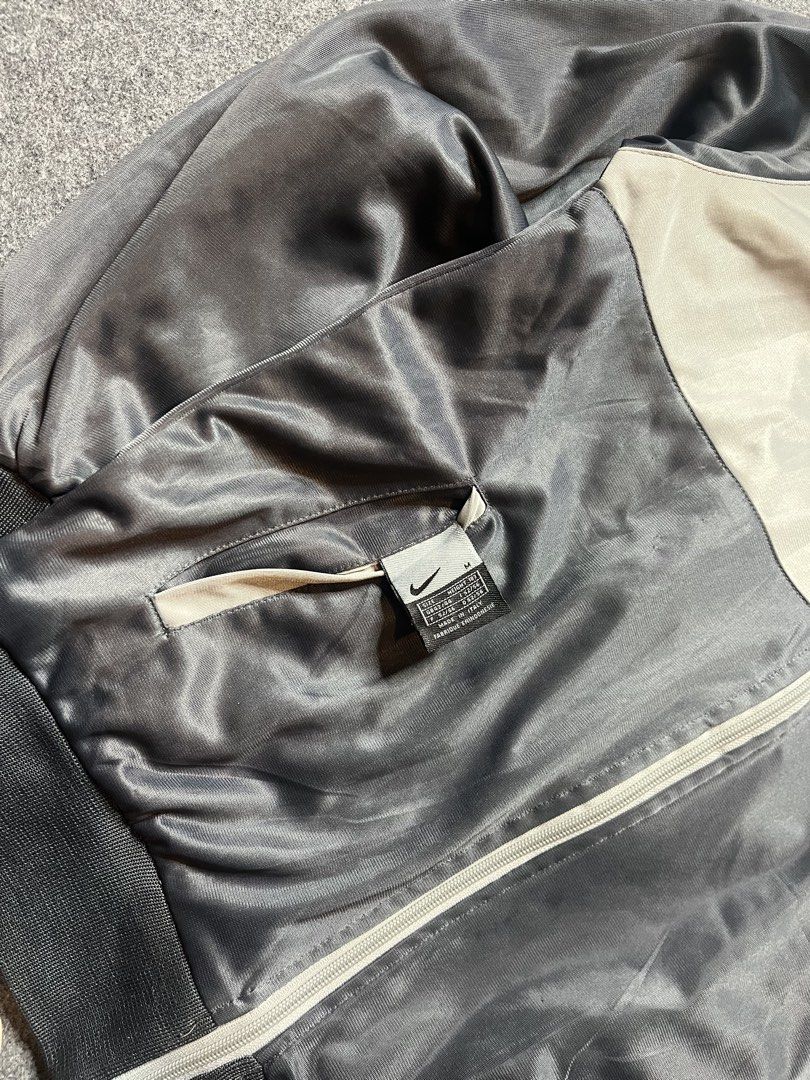 Vintage Nike Track Jacket Grey Black Size M (Category: Coats, Jackets and Outerwear) located in Lapu Lapu. Submitted by softfind (Listing ID 1469823405, Image 3). Description: - Authentic vintage Nike track jacket in a stylish grey and black colorway - Made in Italy with premium quality - Features a full zip closure, stand-up collar with a packable hood, and practical side pockets - Detailed with a large embroidered Nike swoosh on the chest and m