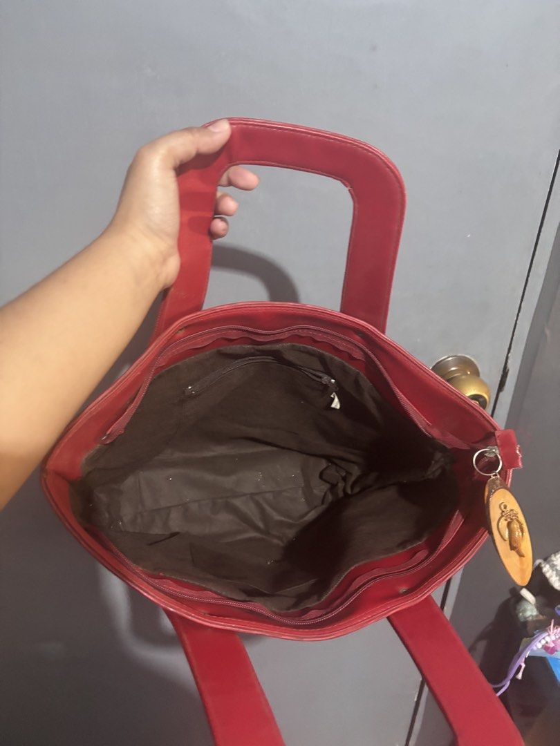 Vintage Red Structured Bag (Category: Tote Bags) located in Bulacan. Submitted by jeipx (Listing ID 1469893239, Image 3). Description: Bright red medium tote bag in textured faux leather. Features a secure zip top, structured handles, inner zip pocket, protective bottom feet, and a cute wooden charm. Perfect for work or daily errands. Zipper working well but the zipper handle fell off. Price negotiable!.