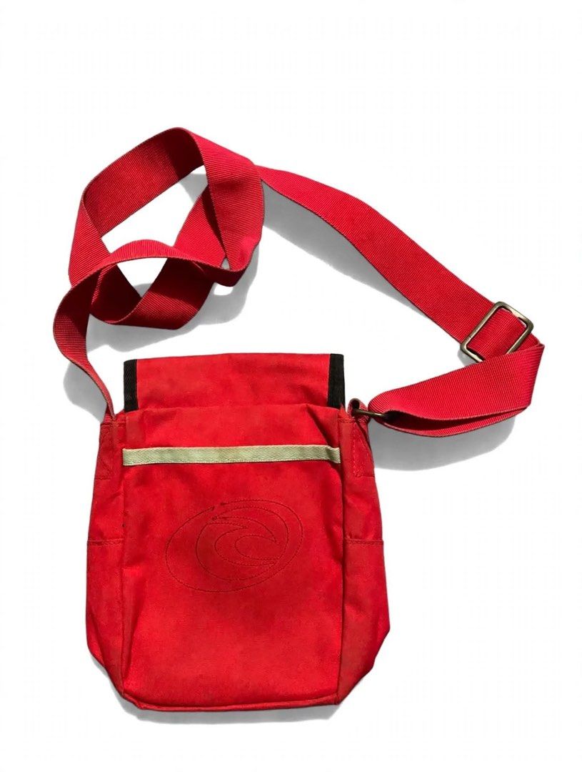 Vintage Rip Curl Red Messenger Shoulder Bag (Category: Sling Bags) located in Quezon City. Submitted by un0oo (Listing ID 1469923769, Image 2). Description: Bright red Rip Curl shoulder bag made from durable canvas material. Flap closure on the front with colorful embroidered flower graphics and branded text detail. Adjustable red strap with metal buckle hardware. Back side includes a tonal circular stitch logo and light piping accent. Handy dail