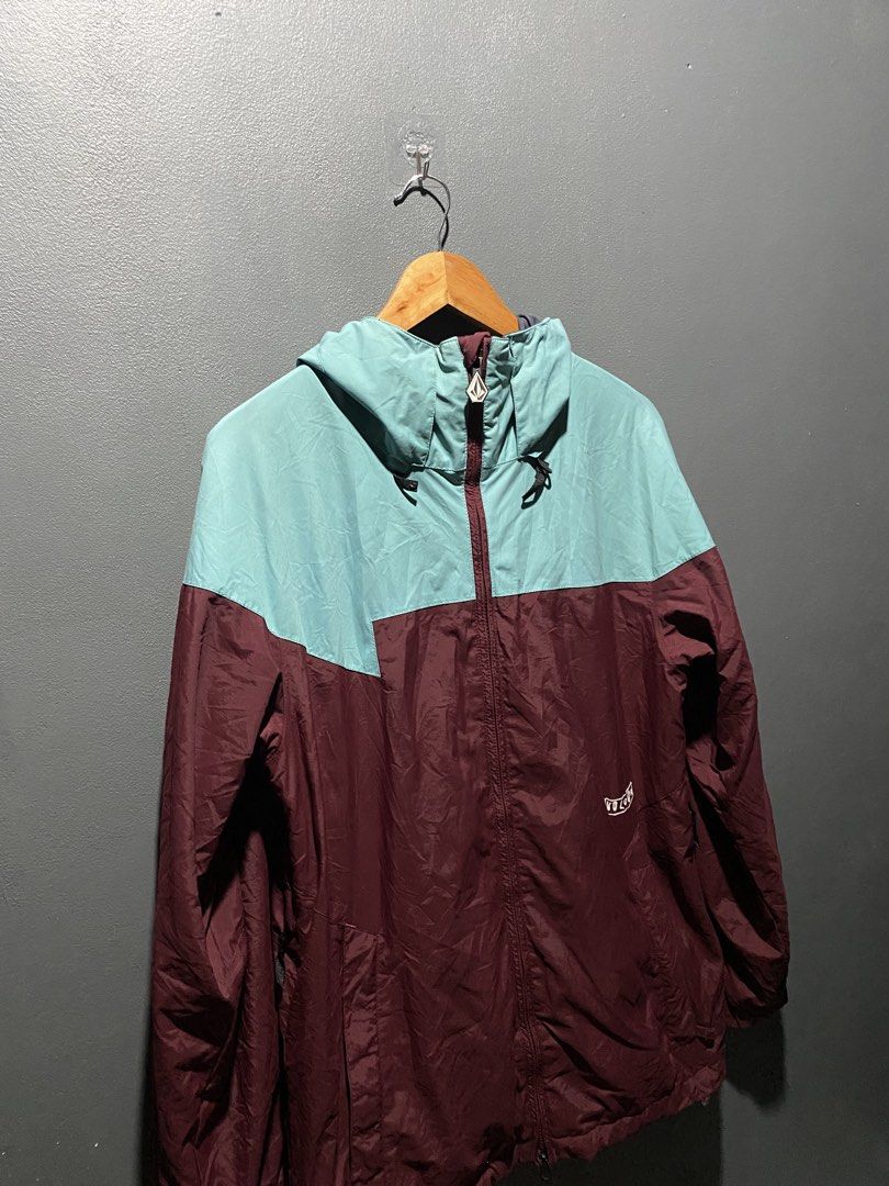 Volcom Colorblock Windbreaker Jacket (Category: Coats, Jackets and Outerwear) located in Lucena. Submitted by handpickthrift (Listing ID 1469840223, Image 3). Description: - Brand: Volcom 22x28.5 dimes - Design: Maroon and teal colorblock with white embroidery on chest and sleeve - Features: Full zip front, attached hood with adjustable drawstrings, and secure zippered pockets - Material: Lightweight, ideal for breezy weather or layering - Condit