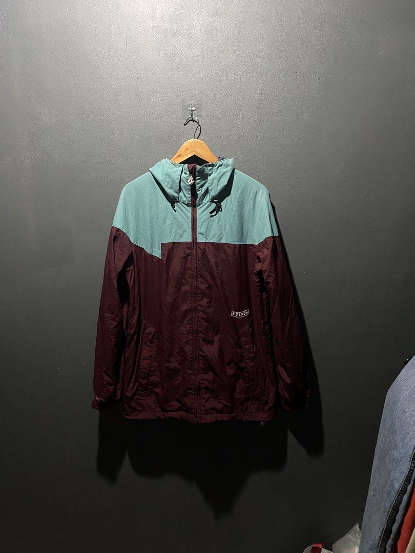 Volcom Colorblock Windbreaker Jacket (Category: Coats, Jackets and Outerwear) located in Lucena. Submitted by handpickthrift (Listing ID 1469840223, Image 1). Description: - Brand: Volcom 22x28.5 dimes - Design: Maroon and teal colorblock with white embroidery on chest and sleeve - Features: Full zip front, attached hood with adjustable drawstrings, and secure zippered pockets - Material: Lightweight, ideal for breezy weather or layering - Condit