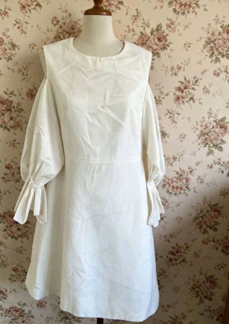 Calvin Klein White Cold Shoulder Midi Dress with Lantern Sleeves (Category: Dresses) located in Manila. Submitted by charlottej01596 (Listing ID 1469783439, Image 1). Description: - Style: White midi dress with a sleek, solid color - Sleeves: Dramatic lantern sleeves with ribbon wrist ties and trendy cold shoulder cutouts - Fit: Crew neckline, fitted waist seam, and slight A-line skirt - Closure: Convenient back zipper - Material: Smooth, comfort