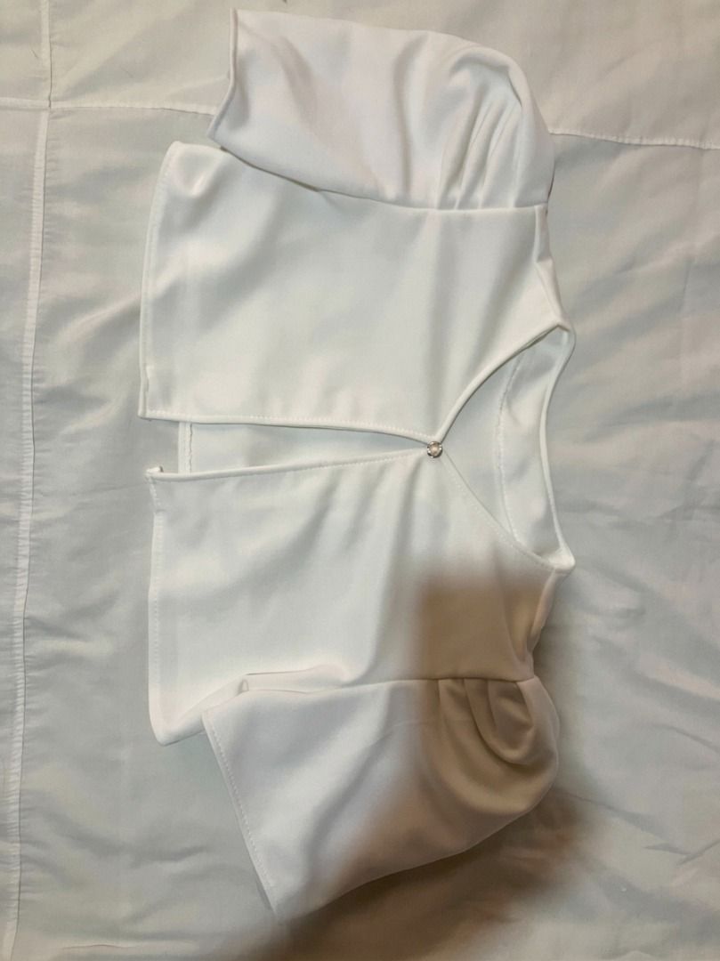 White crop top with puff sleeves and front clasp (Category: Shirts) located in Bacoor. Submitted by maycee.rafallo (Listing ID 1469801732, Image 1). Description: - Color: Clean white - Style: Open front crop top with a single decorative chest clasp - Sleeves: Short sleeves with charming gathering at the shoulders - Fit: Short length, ideal for pairing with high-waisted jeans, skirts, or shorts - Material: Smooth, comfortable fabric.
