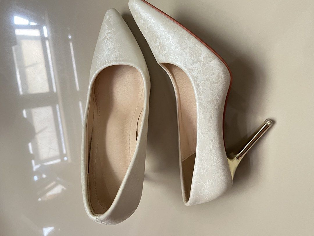 White Floral Pattern Pointed Toe Heels with Gold Stiletto (Category: Heels) located in Manila. Submitted by cleverdeer_fd (Listing ID 1469819231, Image 3). Description: - Style: White heels with a subtle floral pattern and pointed toe - Heel: High stiletto heel in shiny gold - Comfort: Nude inner lining with a cushioned sole - Condition: Worn once - Perfect for events, dates, or dressing up any outfit!.