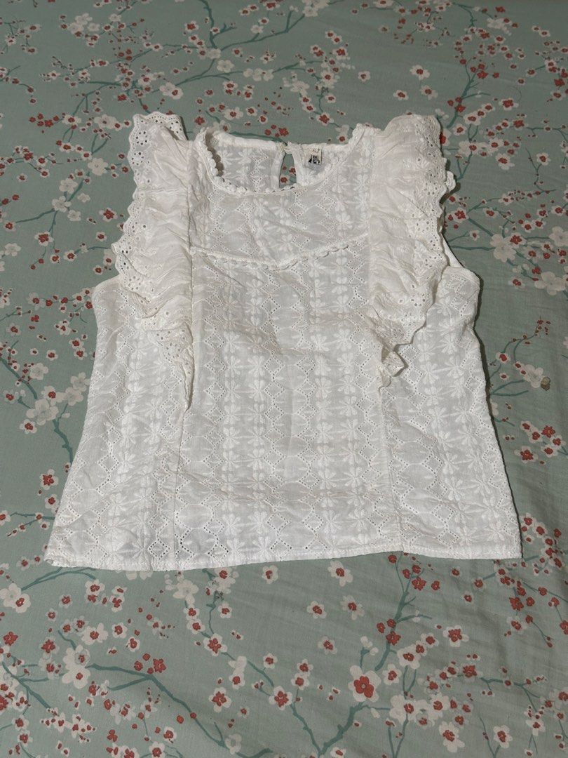 White lace sleeveless ruffled blouse (Category: Sleeveless) located in Mandaluyong City. Submitted by gelatinxx (Listing ID 1469910730, Image 1). Description: - Size: best fits extra small (XS) to small (S) frames - Color: White - Style: Sleeveless top with eye-catching ruffle details on front shoulders - Design: All-over embroidered cut-out patterns - Closure: Button loop at the back neck - Material: Lightweight cotton (super breathable for PH w