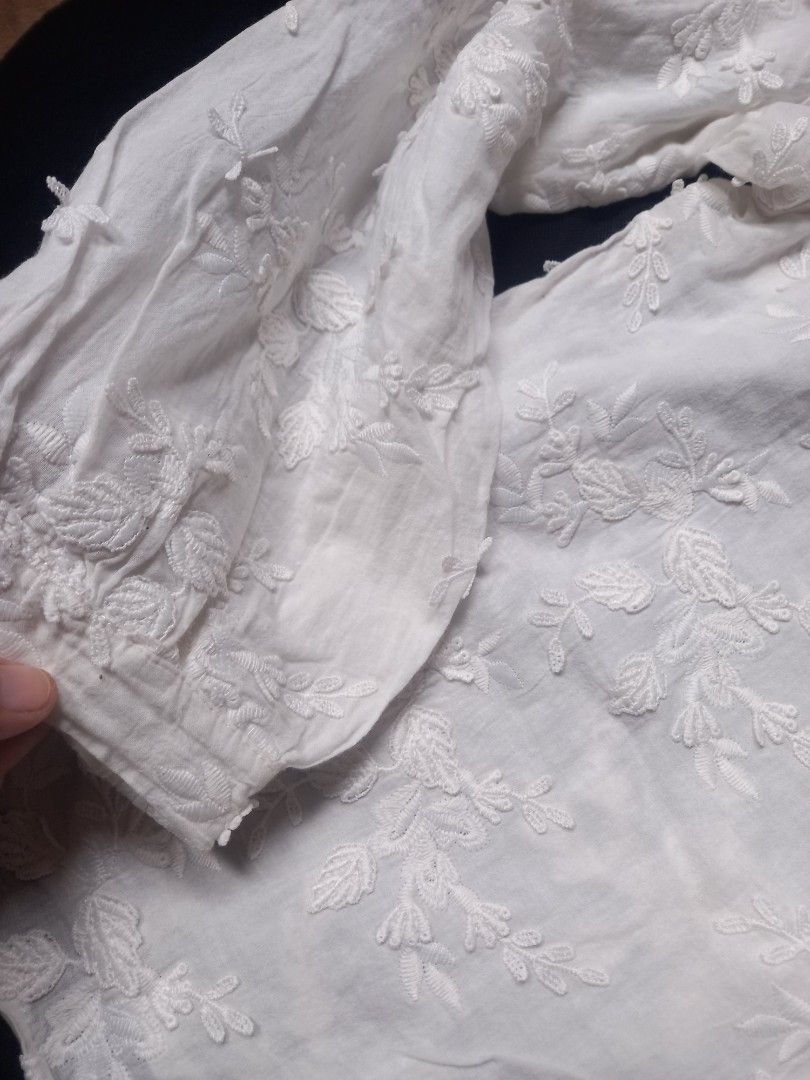 White long-sleeve embroidered button-up blouse (Category: Longsleeves) located in Manila. Submitted by ashibambum_05 (Listing ID 1469771528, Image 2). Description: - Color: White -Best fit Medium Large - Material: Lightweight cotton-blend fabric - Design: All-over tonal floral embroidery - Details: Button-up front, collarless neckline, and gathered sleeve cuffs - Versatility: Great basic piece for layering or wearing on its own.