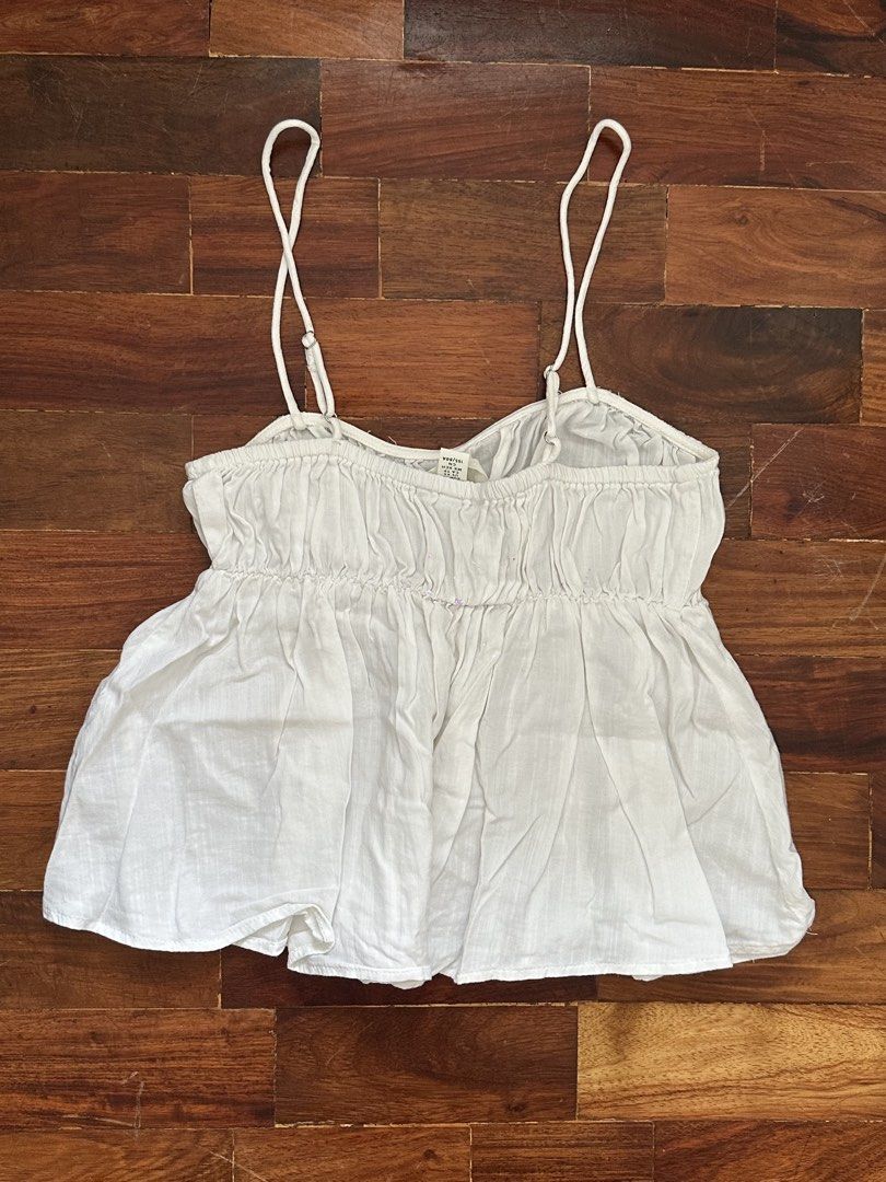White Ruched Camisole Top Size XS (Category: Sleeveless) located in Cainta. Submitted by buy.preloved (Listing ID 1469790393, Image 3). Description: - Color: White - Size: EUR XS / US XS - Design: Thin adjustable straps, elasticized ruched bodice, and flared peplum hem - Material: Lightweight and breathable fabric, ideal for warm weather - Condition: Clean, excellent pre-loved condition.
