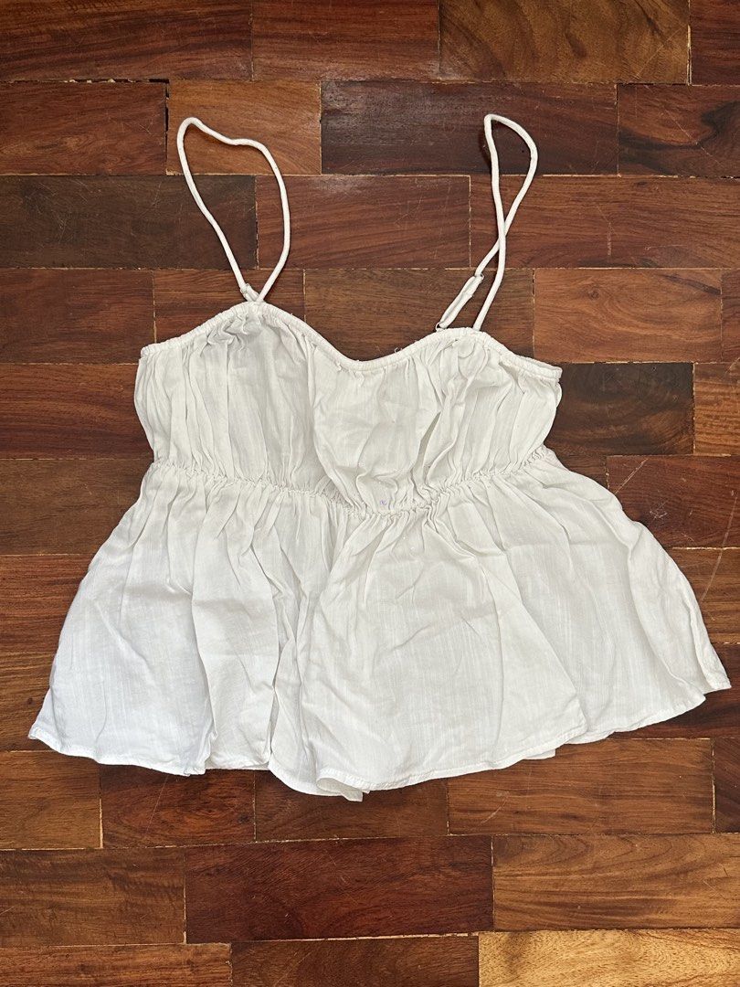 White Ruched Camisole Top Size XS (Category: Sleeveless) located in Cainta. Submitted by buy.preloved (Listing ID 1469790393, Image 1). Description: - Color: White - Size: EUR XS / US XS - Design: Thin adjustable straps, elasticized ruched bodice, and flared peplum hem - Material: Lightweight and breathable fabric, ideal for warm weather - Condition: Clean, excellent pre-loved condition.