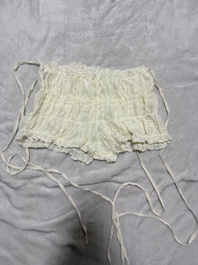 White Ruched Ruffle Tie-Side Shorts (Category: Shorts) located in Los Banos. Submitted by sashimituna (Listing ID 1469774620, Image 1). Description: - Color/Design: White textured fabric with an all-over ruched design - Details: Playful ruffle hems and long adjustable side ties - Fit & Comfort: Lightweight material with a comfortable, stretchy elastic waistband - Style: Cottagecore, beach cover-up, or general summer wear - Versatility: Easy to mi