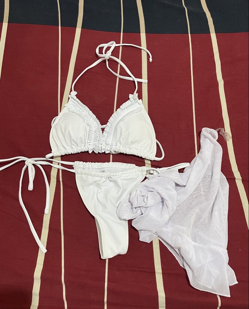 White Ruffle Bikini Set with Cover Up Sarong (Category: Bikinis & Swimsuits) located in Manila. Submitted by quickturtle_b8d593 (Listing ID 1469828877, Image 1). Description: - 3-Piece Set: Includes a triangle bikini top, side-tie bottoms, and a sheer white mesh sarong - Design: Chic ruffled trim along the top for a feminine touch - Fit: Adjustable side-tie bottoms for a custom fit - Condition: Like-new, clean fabric with zero flaws - Ideal For: 